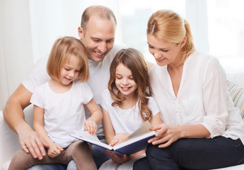 smiling family and two little girls with book