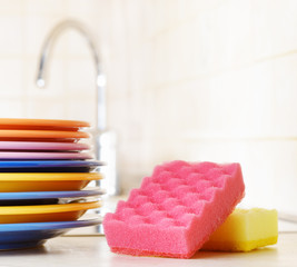 Several plates and a kitchen sponge. Dishwashing concept