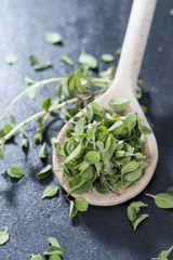 Cutted Oregano on a wooden spoon