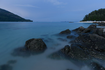 Fototapeta na wymiar beach with rocks and waves; sunset background