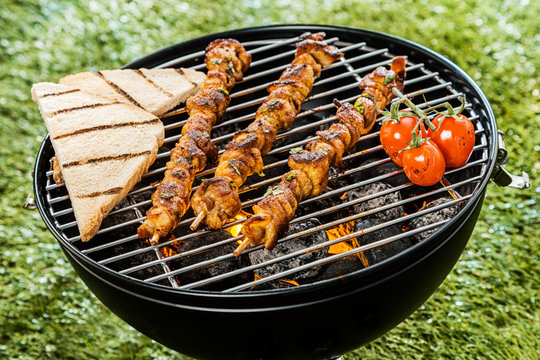 Delicious meat kebabs grilling on a BBQ fire