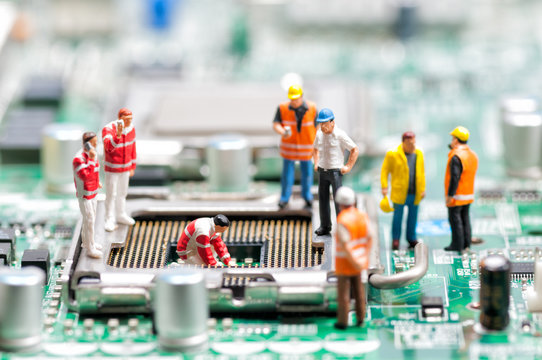 Team of engineers repairing circuit board - Powered by Adobe
