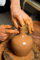 hands of a potter, creating an earthen jar