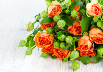 orange roses on wooden surface