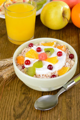 Delicious oatmeal with fruit in bowl on table close-up