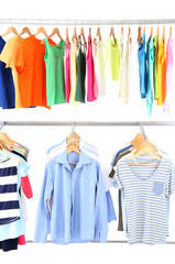 Different clothes on hangers, on gray background