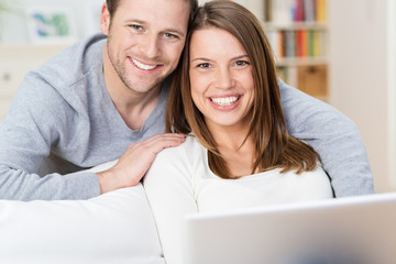 glückliches ehepaar zuhause mit computer