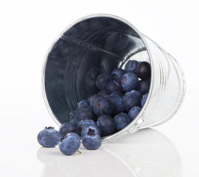 blueberry berries in a metal bucket, isolated on white backgroun
