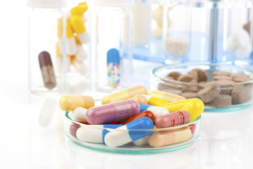 Colorful medical capsules in Petri dishes. Laboratory concept.