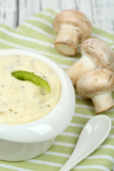 Delicate mushroom sauce in bowl on wooden table close-up