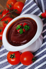 Tomato sauce in bowl on wooden table close-up