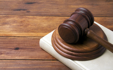 Wooden gavel and book on wooden background