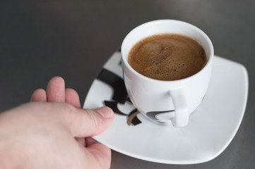 man takes a cup of coffee
