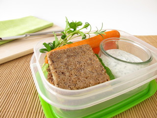 Brotbox mit Vollkornbrot und Möhren mit Kräuter-Joghurt