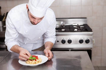 Male chef completing pasta.. - 62731639