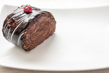 Chocolate cake with chocolate icing on white plate