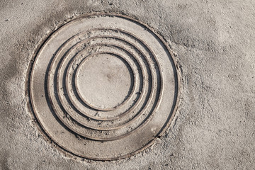 Fototapeta na wymiar Round sewer manhole on urban asphalt road