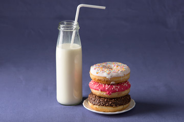 Donut with milk at violet background