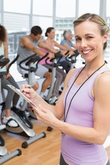 Trainer with people working out at spinning class