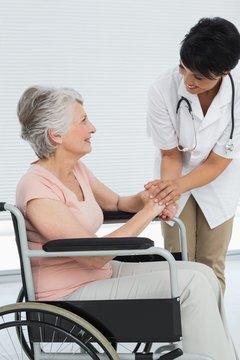 Female doctor talking to a senior patient in wheelchair
