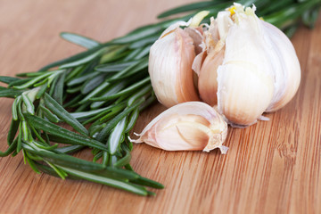 Rosemary and garlic on a wooden chopping board