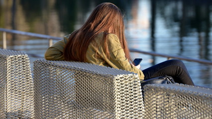 fille assise regardant son tel