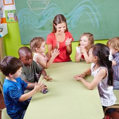 Kinder klatschen in Hände im Kindergarten