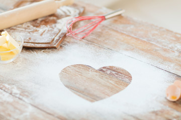 close up of heart of flour on wooden table at home