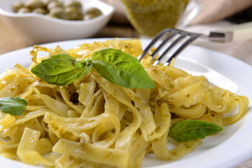 Delicious pasta with pesto on plate on table close-up
