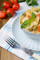 Delicious pasta with tomatoes on plate on table close-up