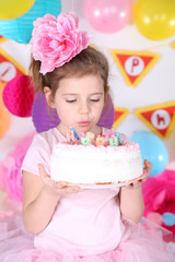 Pretty little girl with cake celebrate her birthday