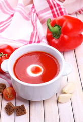 Tasty tomato soup and vegetables on wooden table