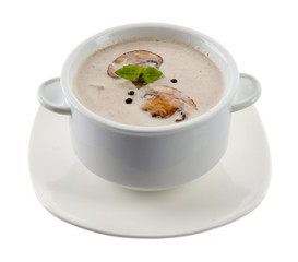 Mushroom soup in white bowl, on plate, isolated on white