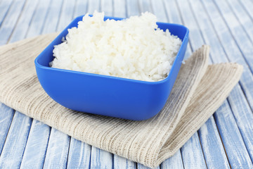 Cooked rice in bowl on wooden background