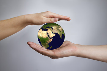 The Earth in a female and male hands