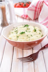 Delicious mashed potatoes with greens in bowl on table close-up