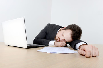 Young businessman sleeping on the office desk