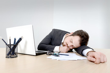 Young businessman sleeping on the office desk