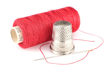 Spool of thread, thimble and sewing needle