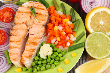 Tasty grilled salmon with vegetables, close up