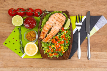 Tasty grilled salmon with vegetables, on bamboo mat