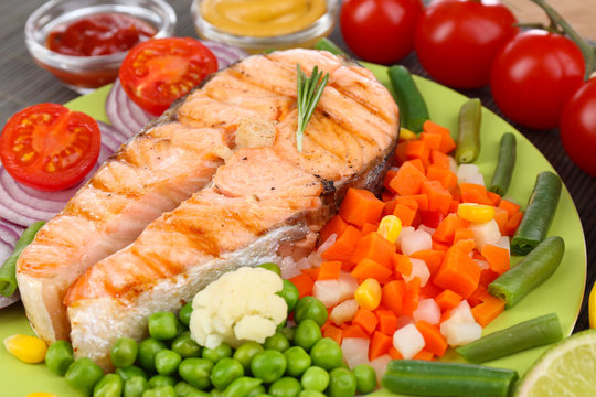 Tasty grilled salmon with vegetables, close up