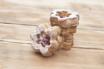 Flowers shape cookies cover with powder sugar on a wooden table