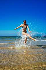 Splash. Young Woman Enjoying in water on the Beach. Summertime