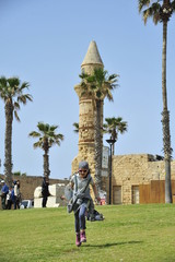 Girl running on the grass in Caesarea NP, Israel