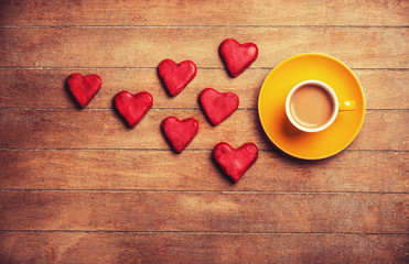 Cup of coffee and cookie on a wooden table.