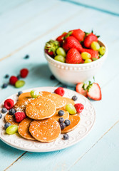 Pancakes with berries on wooden background