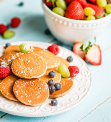 Pancakes with berries on wooden background