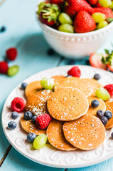 Pancakes with berries on wooden background
