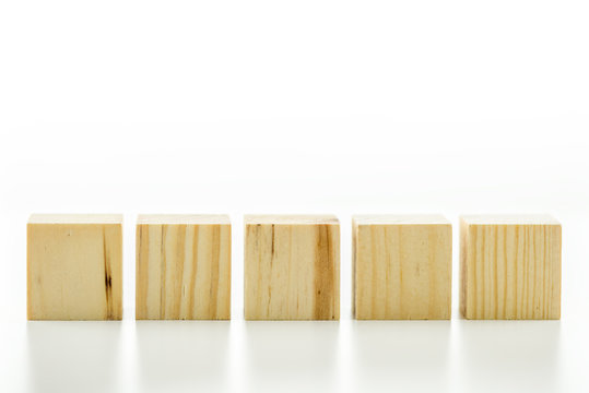 Row of five blank wooden blocks on a white background